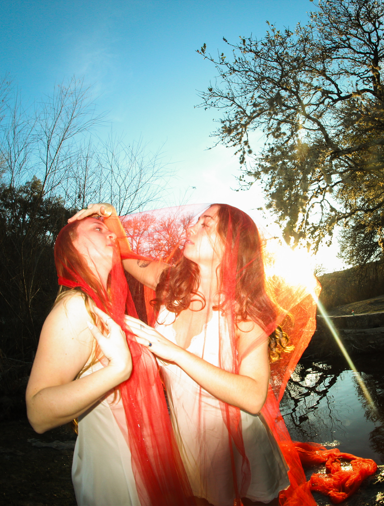 Abstain Devour — two dancers with red veil at sunset